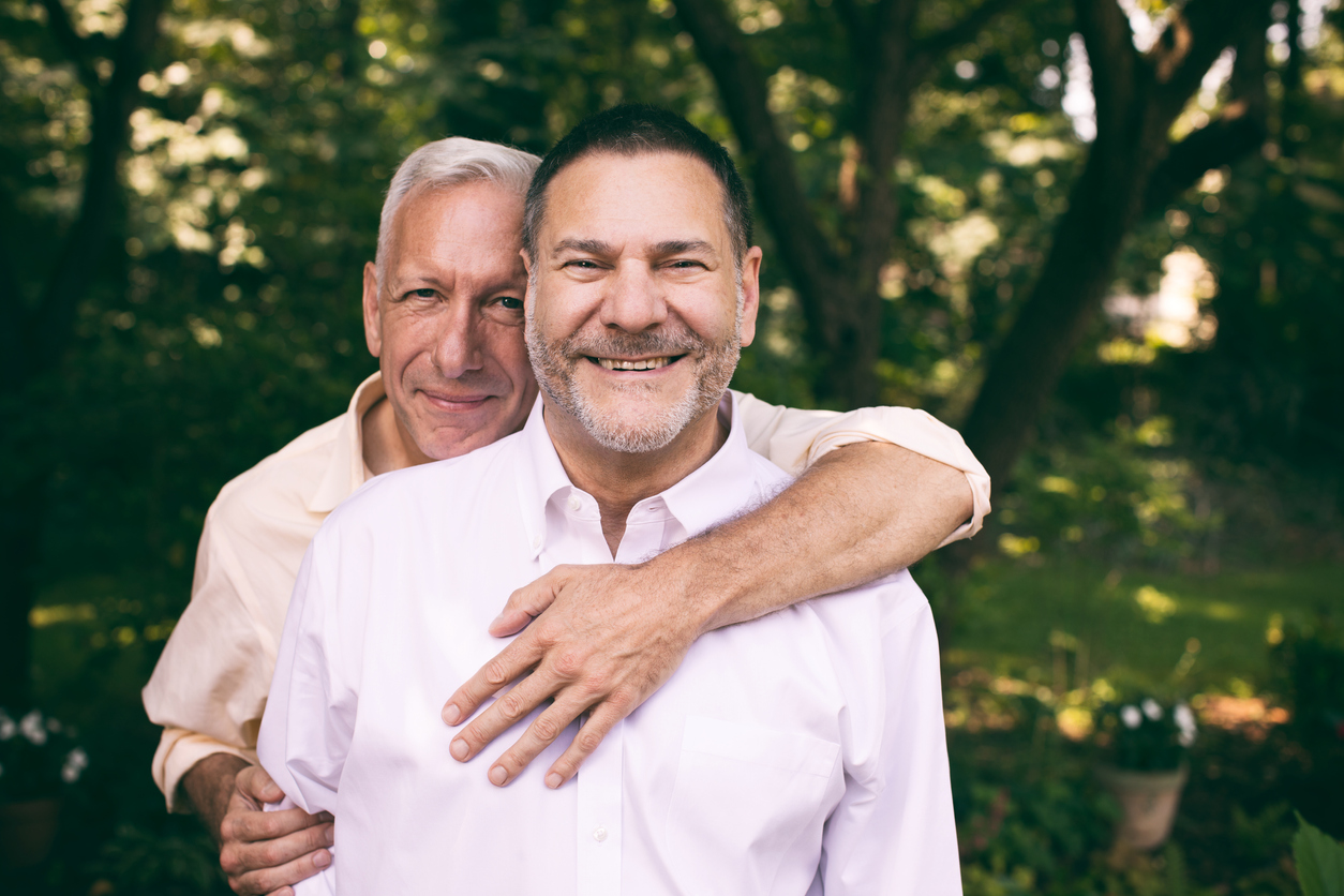 loving middle-aged gay couple surrounded by nature.